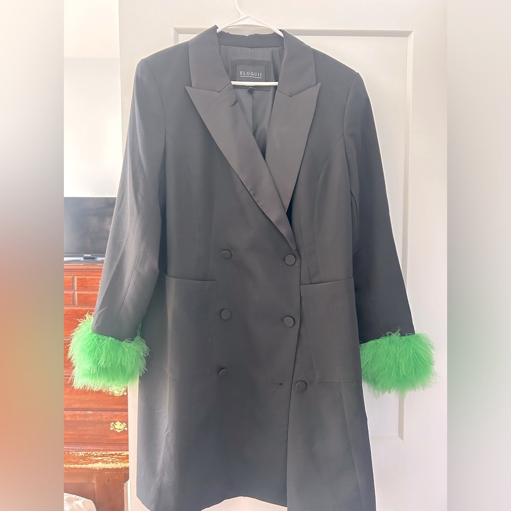Eloquii black blazer dress with green feather trimmed sleeves.